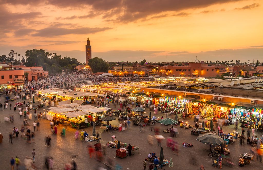 Sunset over Marrakech, Morocco, showcasing vibrant colors illuminating the city's historic architecture and bustling streets in Jamaa Lefna Square is one of the best things to do in Marrakech